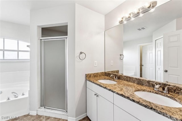 bathroom with a stall shower, a sink, and a bath