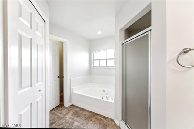 bathroom with a stall shower, a garden tub, and recessed lighting