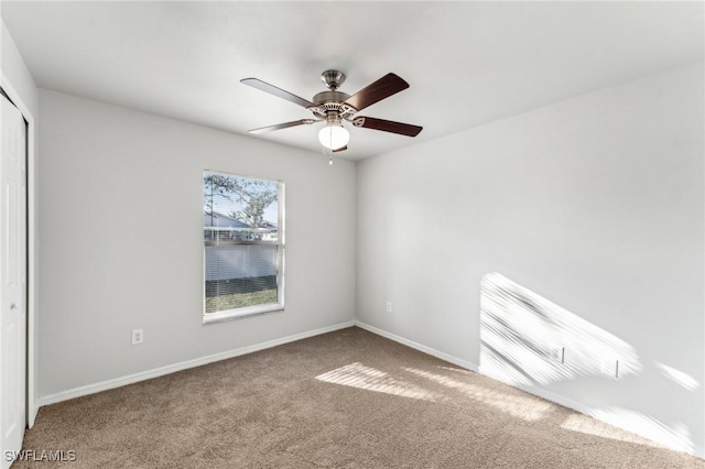 unfurnished bedroom featuring a ceiling fan, carpet, a closet, and baseboards