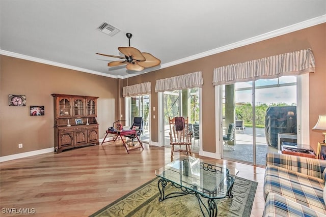 living room with ceiling fan, ornamental molding, and light hardwood / wood-style flooring