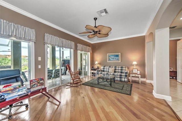 living room featuring crown molding, light hardwood / wood-style floors, and ceiling fan