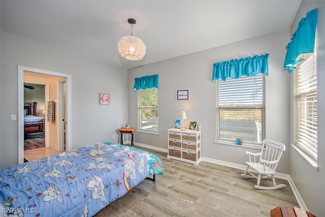 bedroom with multiple windows and hardwood / wood-style floors