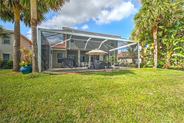 rear view of house with a lanai, a patio area, and a lawn