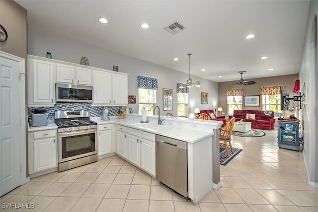 kitchen featuring white cabinetry, appliances with stainless steel finishes, sink, and kitchen peninsula