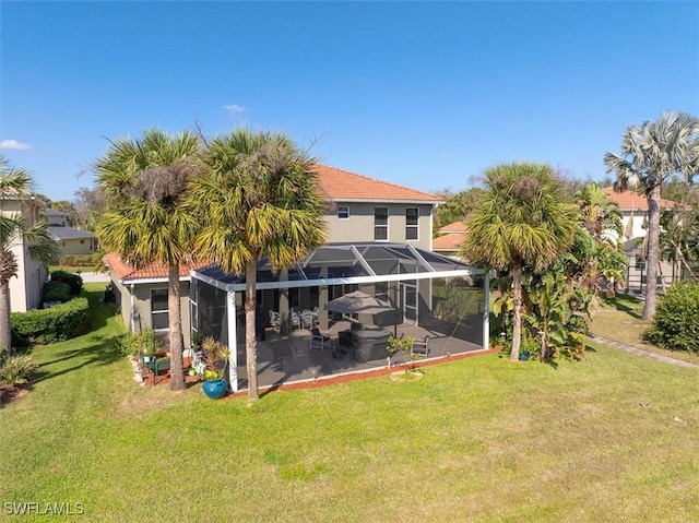 rear view of property featuring a yard, a lanai, and a patio