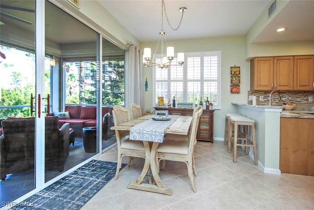 tiled dining room featuring a notable chandelier