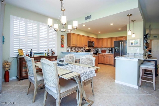 tiled dining room featuring a chandelier