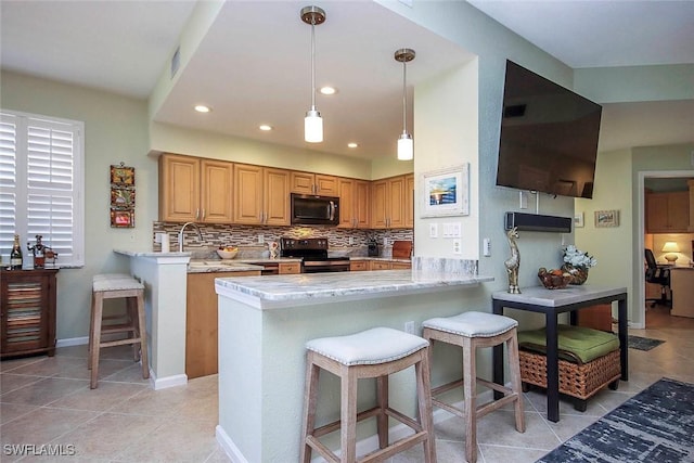 kitchen with tasteful backsplash, black / electric stove, a breakfast bar area, and kitchen peninsula