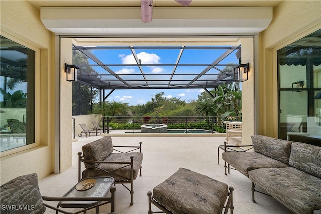 view of patio / terrace featuring an outdoor hangout area and glass enclosure