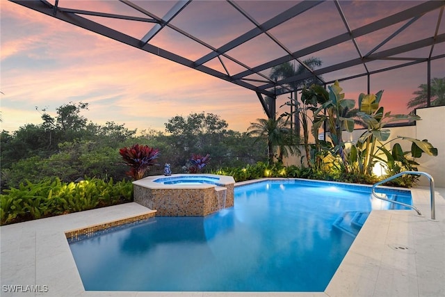 pool at dusk with an in ground hot tub, a lanai, and a patio area