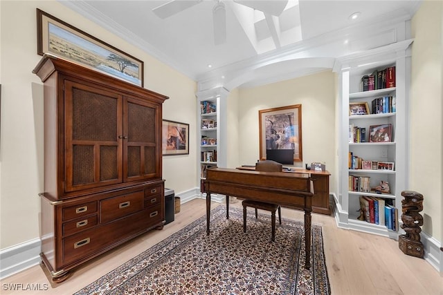 office featuring crown molding, ceiling fan, light wood-type flooring, and built in shelves