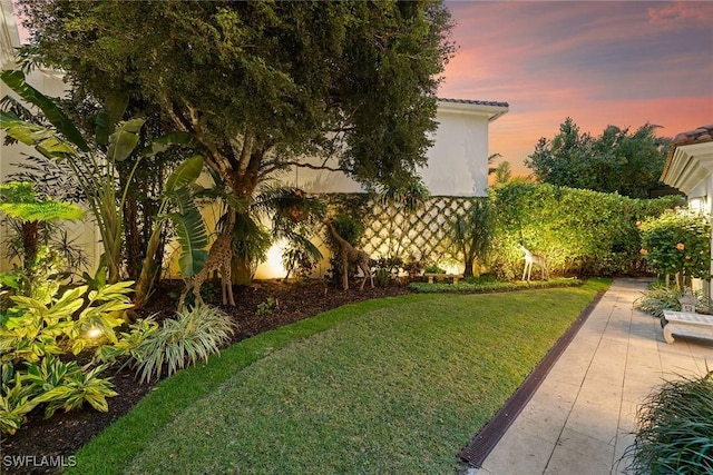 yard at dusk with a patio area