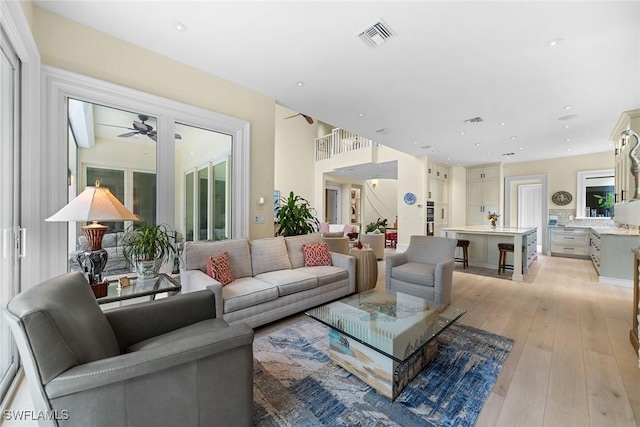 living room with ceiling fan and light hardwood / wood-style flooring