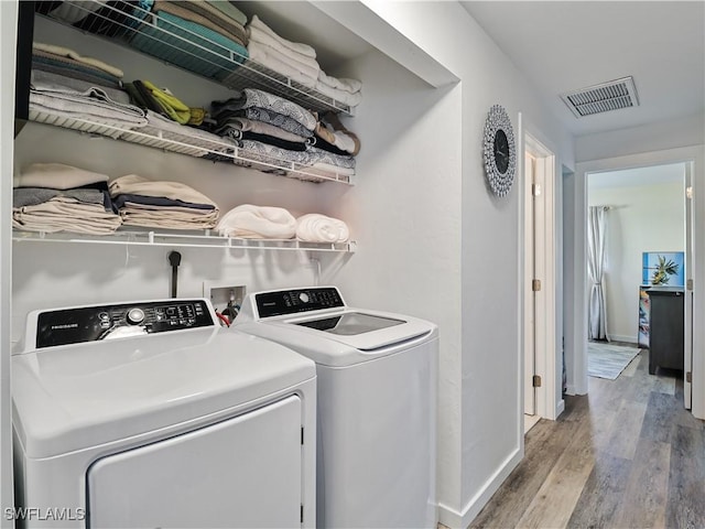 laundry area with separate washer and dryer and light wood-type flooring