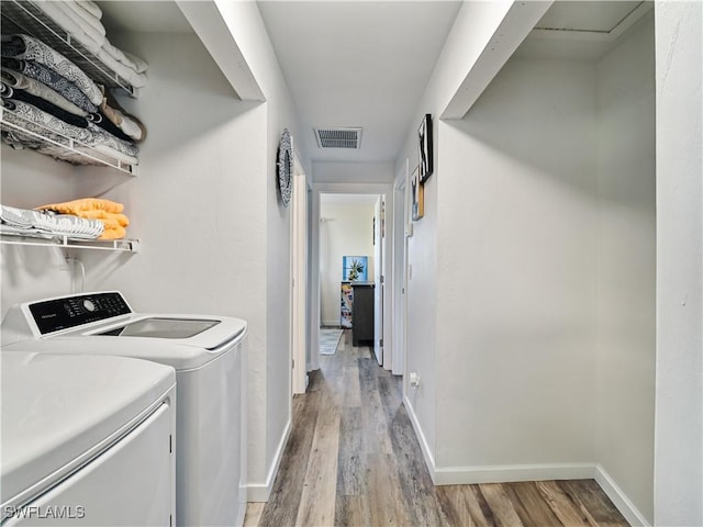 washroom with wood-type flooring and washing machine and clothes dryer