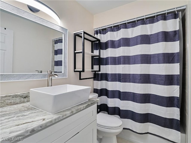 bathroom featuring vanity, curtained shower, and toilet