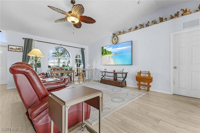 living room featuring ceiling fan, vaulted ceiling, and light wood-type flooring