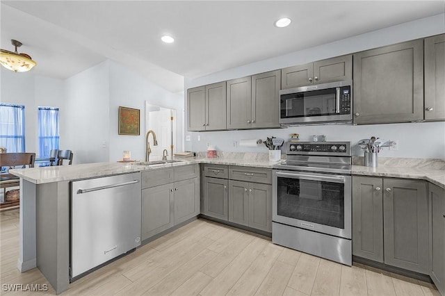 kitchen with gray cabinetry, sink, stainless steel appliances, and kitchen peninsula