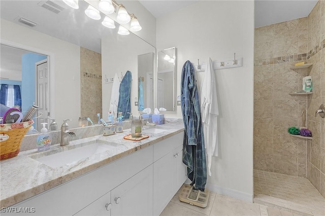 bathroom featuring tile patterned floors, vanity, and tiled shower