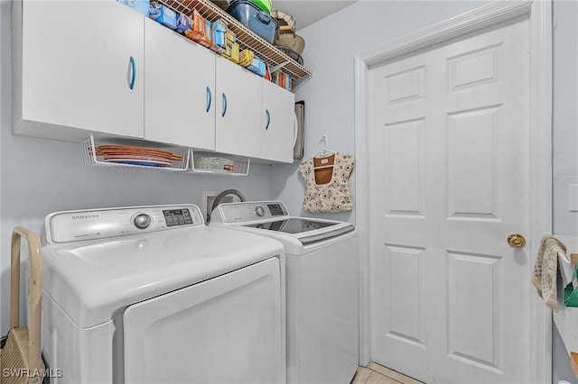 washroom with cabinets and washing machine and clothes dryer