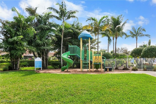 communal playground featuring a yard and fence