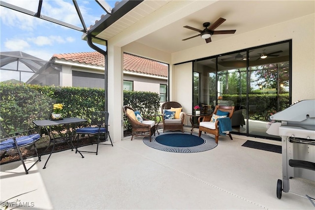 view of patio / terrace featuring a lanai, a ceiling fan, and outdoor dining space