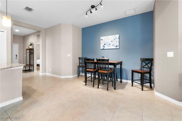 dining room featuring light tile patterned flooring, visible vents, and baseboards