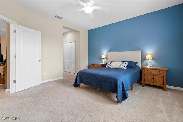 carpeted bedroom with baseboards, visible vents, ceiling fan, and a closet