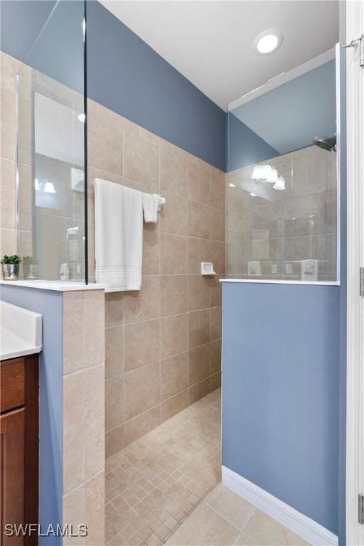 full bathroom featuring tile patterned flooring, walk in shower, and vanity