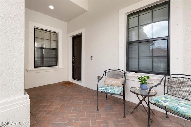 entrance to property featuring a patio and stucco siding