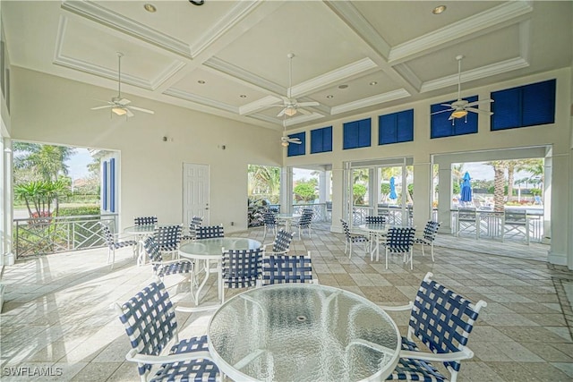 sunroom / solarium featuring a ceiling fan, coffered ceiling, and beam ceiling