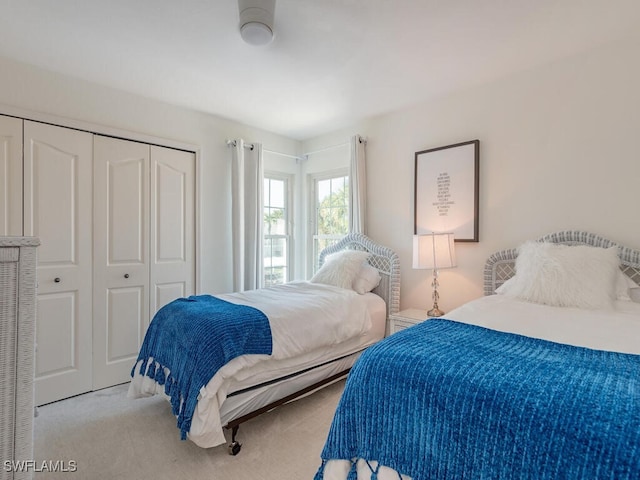 bedroom featuring light colored carpet and a closet