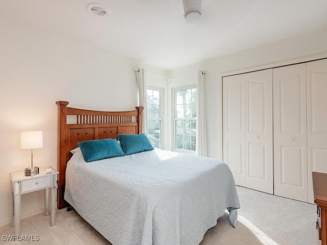 bedroom featuring light colored carpet and a closet