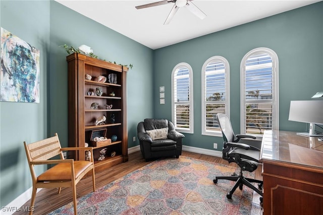 office area with ceiling fan, wood finished floors, and baseboards