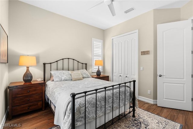 bedroom with baseboards, visible vents, a ceiling fan, dark wood-style floors, and a closet