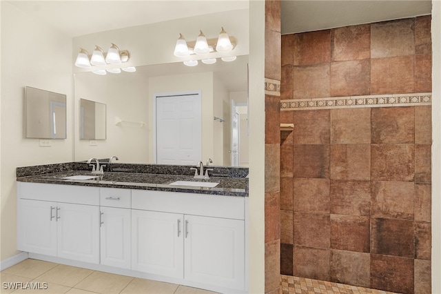 bathroom featuring walk in shower, a sink, and tile patterned floors