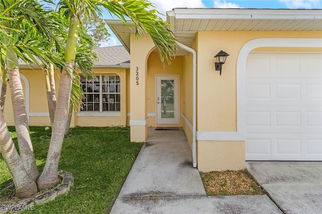 property entrance with a garage, roof with shingles, and stucco siding