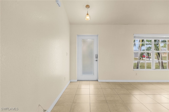 empty room featuring light tile patterned floors and baseboards