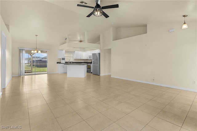 unfurnished living room with high vaulted ceiling, light tile patterned flooring, baseboards, and ceiling fan with notable chandelier