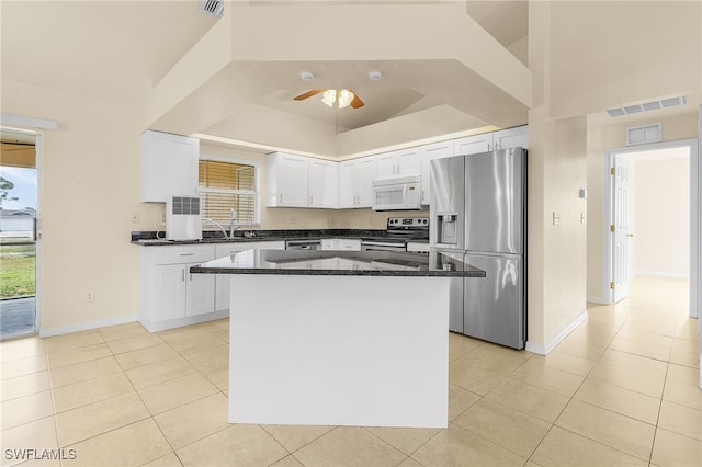 kitchen featuring light tile patterned floors, appliances with stainless steel finishes, and white cabinets