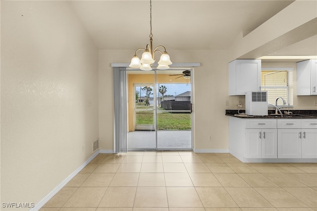 kitchen with visible vents, ceiling fan with notable chandelier, white cabinetry, and baseboards