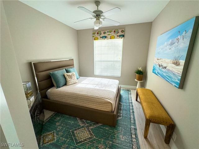 bedroom with ceiling fan, baseboards, and wood finished floors