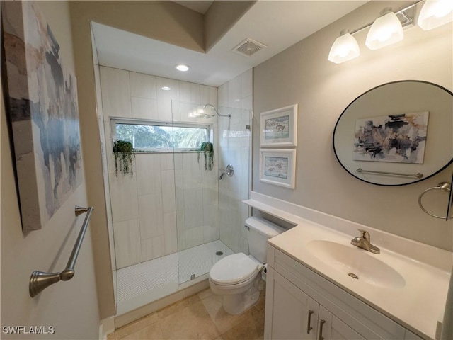 bathroom featuring toilet, a stall shower, vanity, and visible vents