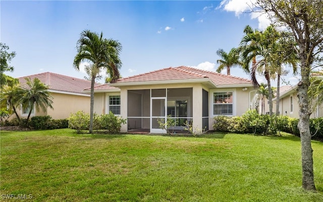 back of house with a yard and a sunroom