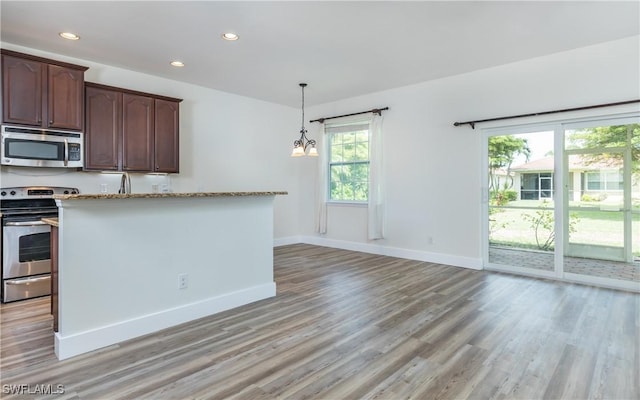 kitchen featuring dark brown cabinetry, light stone counters, light hardwood / wood-style flooring, and stainless steel appliances