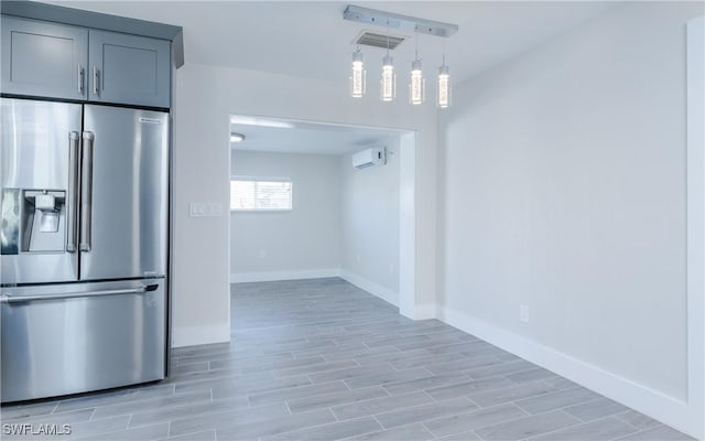 kitchen with hanging light fixtures, high quality fridge, and a wall mounted AC