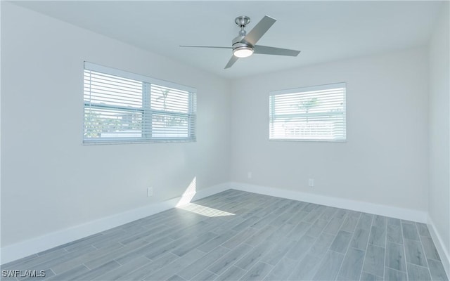 spare room with ceiling fan and light wood-type flooring