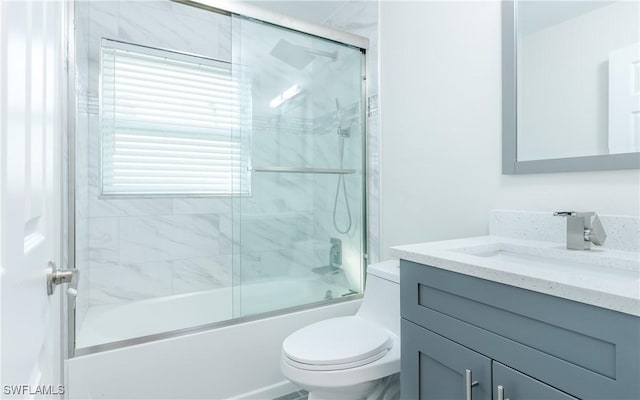 full bathroom with vanity, shower / bath combination with glass door, and toilet