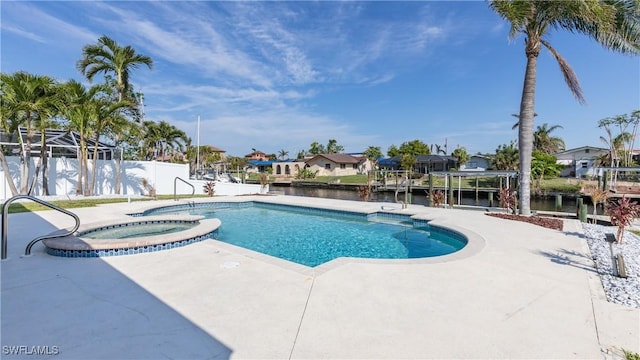 view of swimming pool featuring a water view, an in ground hot tub, and a patio area