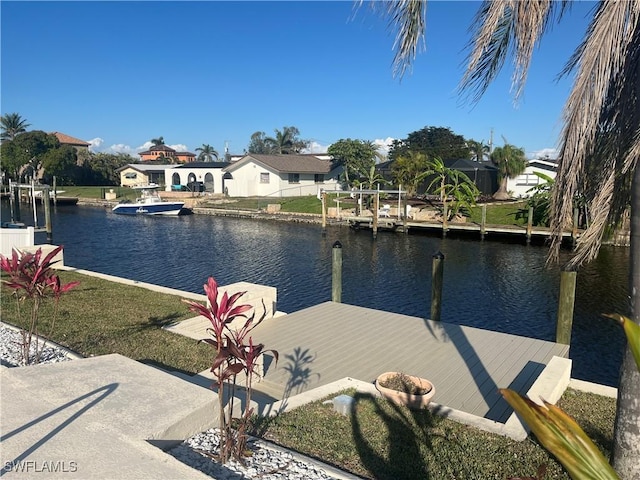 dock area with a water view and a yard